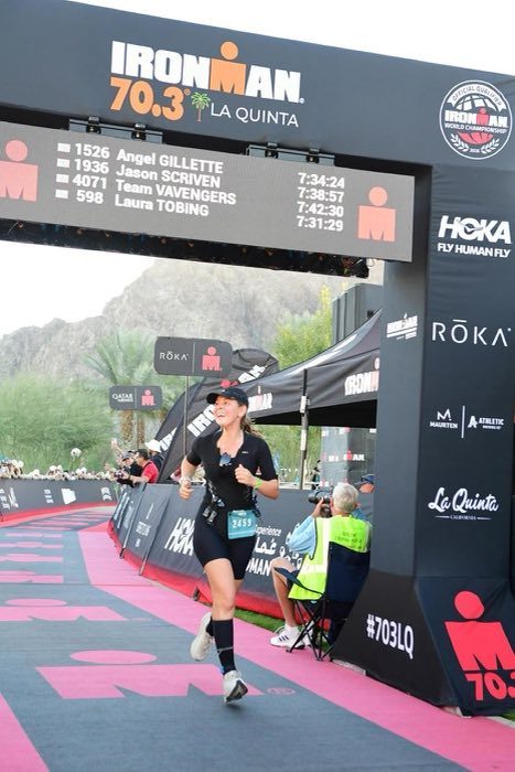 Annette Serio Haddad crossing the finish line at Ironman 70.3 La Quinta
